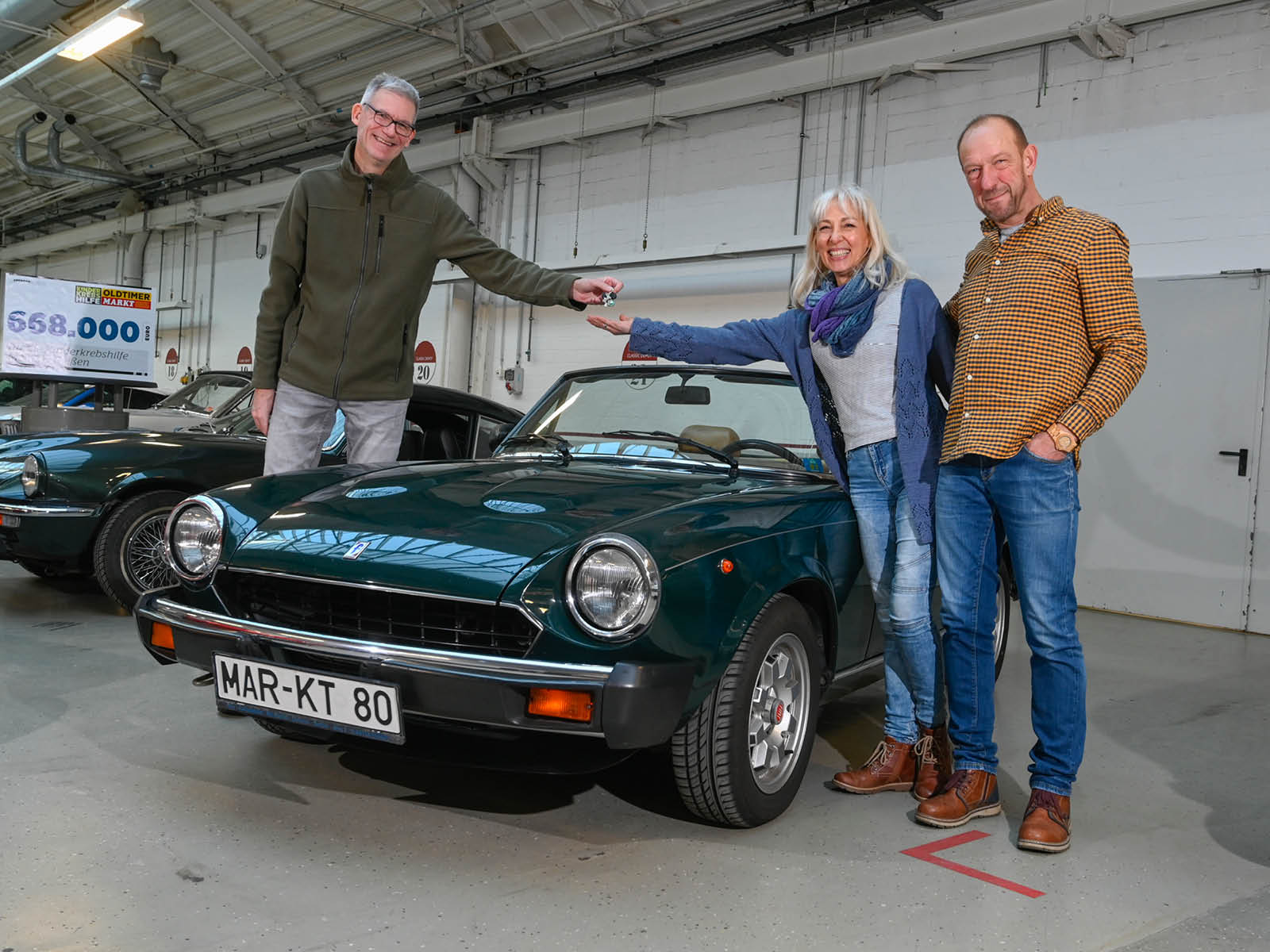 Spender Andreas Bennerscheidt-Krieg (links) übergab die Schlüssel seines Pininfarina Spider höchstpersönlich an Gewinnerin Kirsten Schön, die sich gemeinsam mit Ehemann Josef Stärk freut 